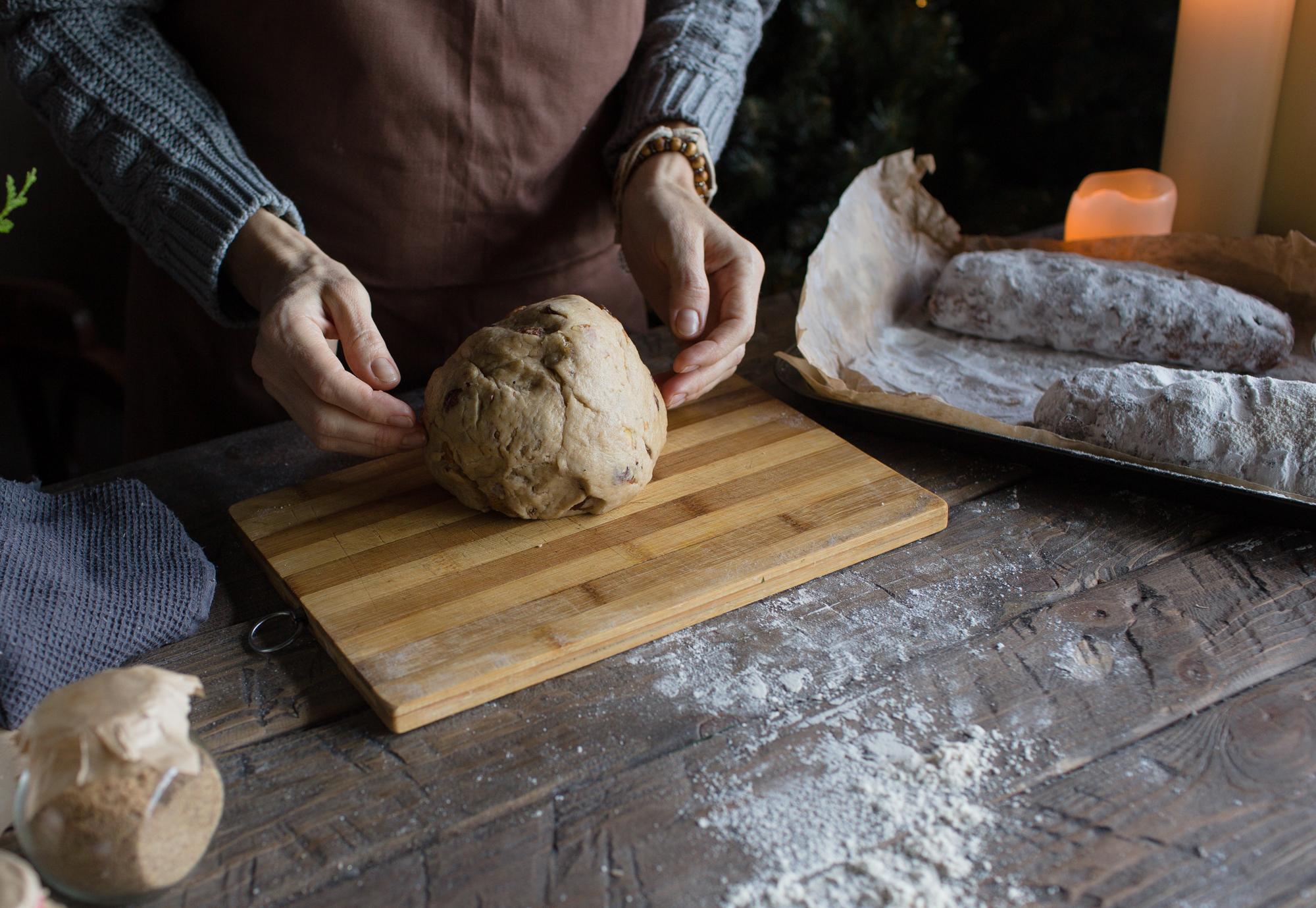 Hands kneading dough on wooden table